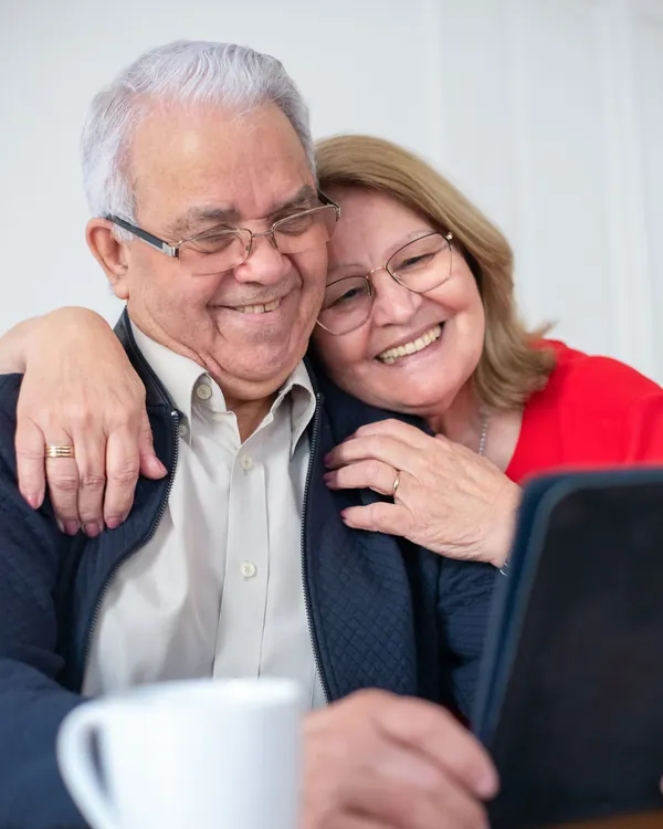Casal de idosos sorrindo em casa